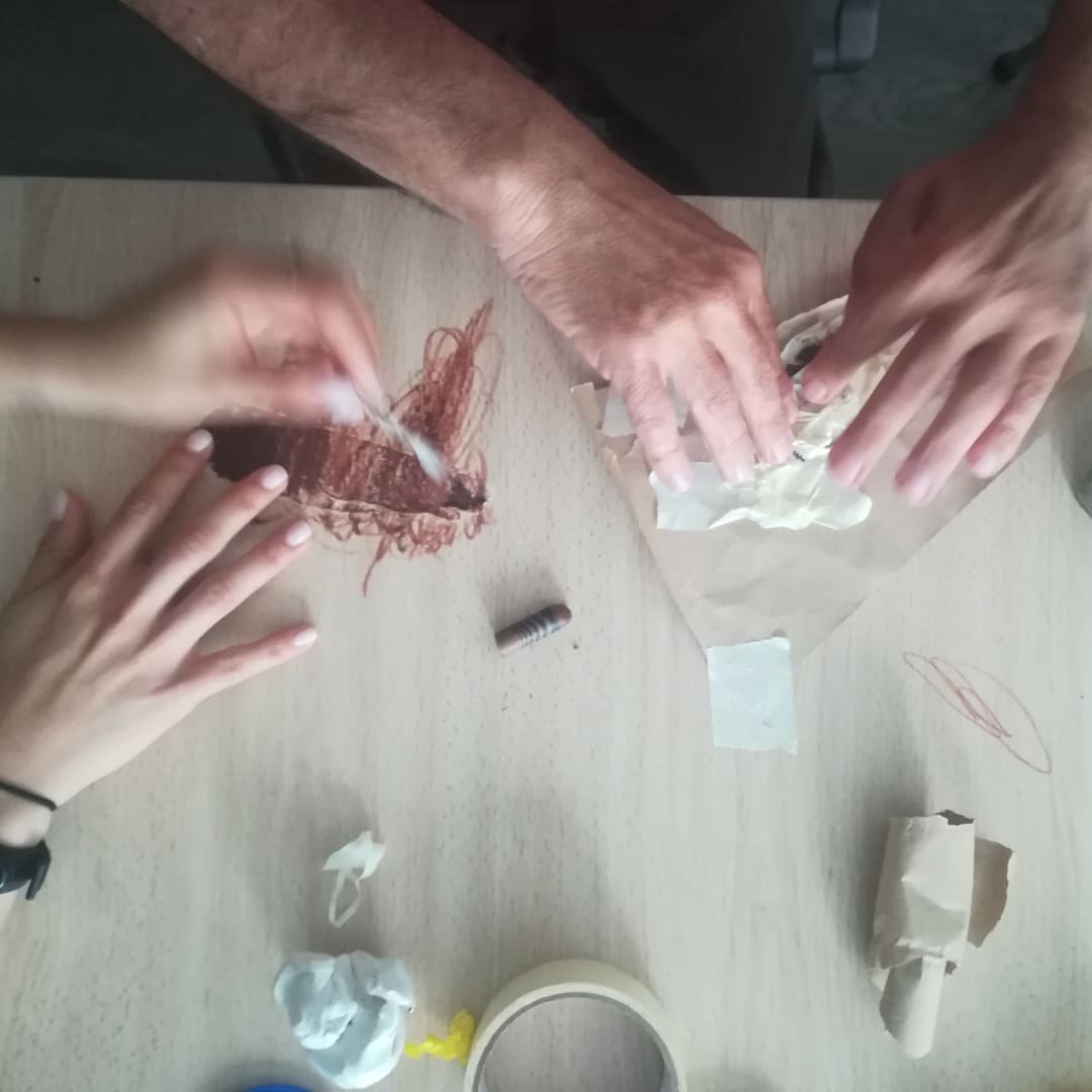 Adultos creando durante una sesión de arteterapia. Vemos sus manos trabajando materiales como la plastilina y el papel