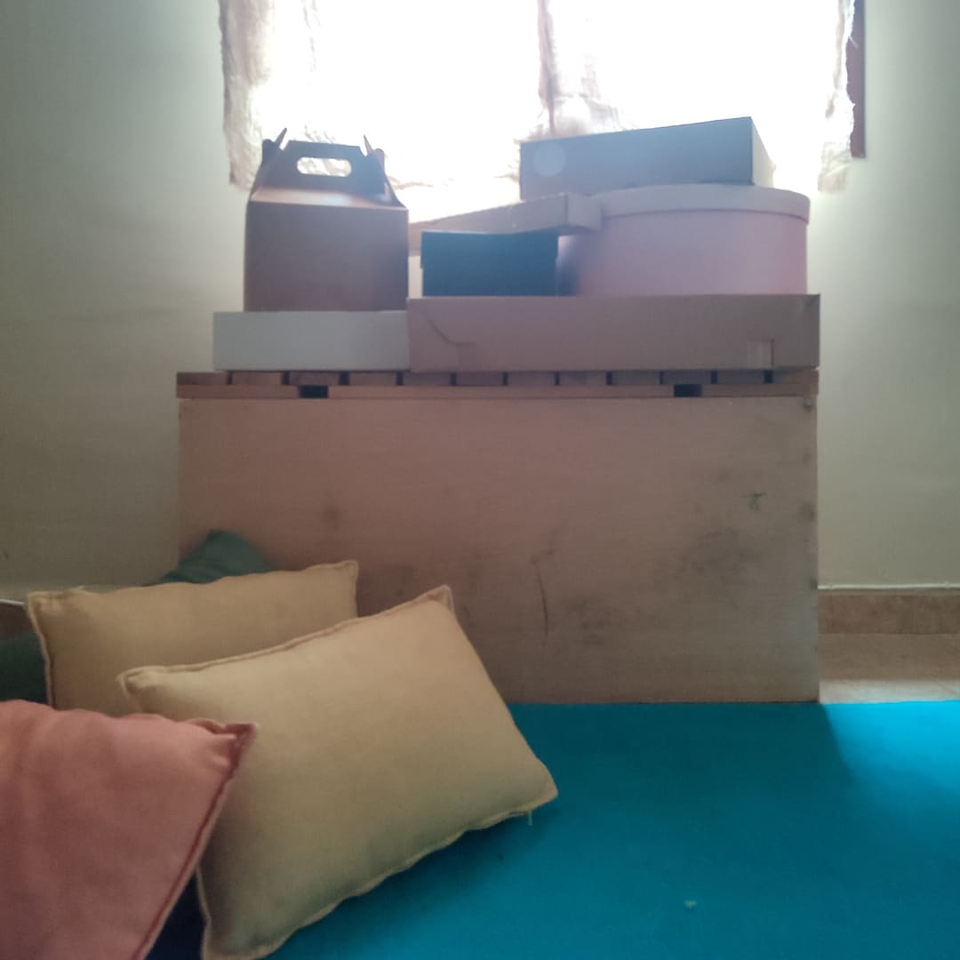 Preparación del espacio para una sesión de arteterapia para adultos, vemos cojines y diversas cajas.